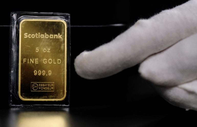 A worker points at a gold bar at Barcelona Gold store in Barcelona, Spain January 26, 2026. REUTERS/Nacho Doce