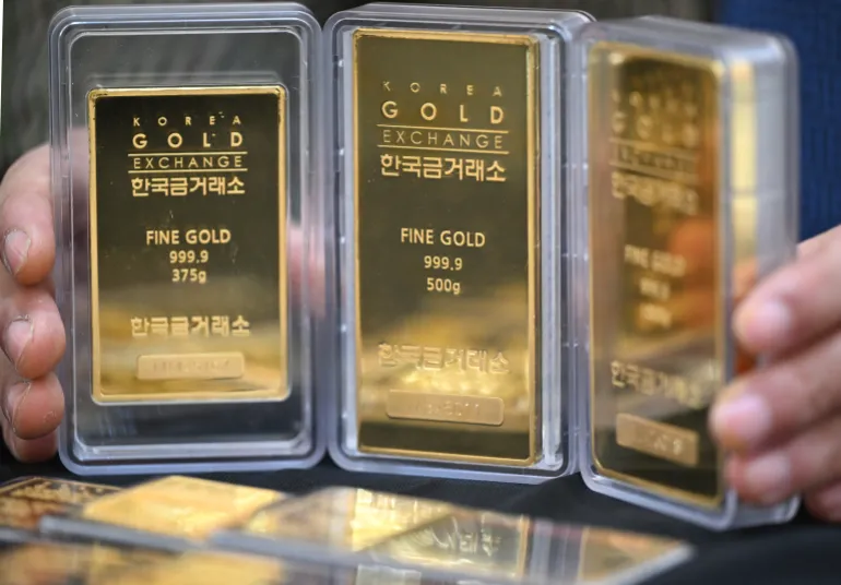 An employee displays gold bars at a store of the Korea Gold Exchange in Seoul on January 26, 2026.