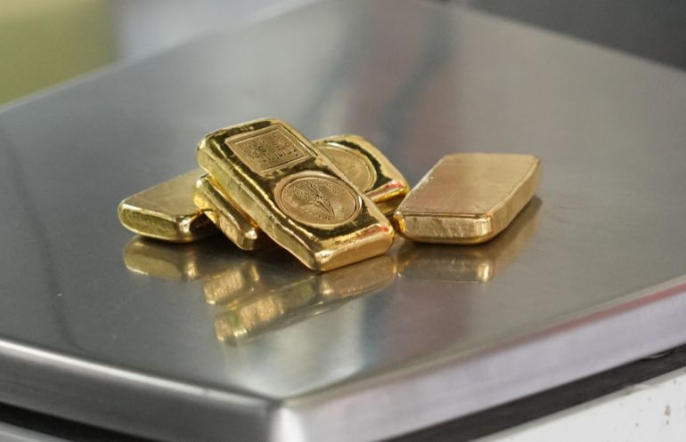 A gold jeweller weighs gold bars at a shop in Bangkok, Thailand, Monday, March 2, 2026. (AP Photo/Sakchai Lalit)