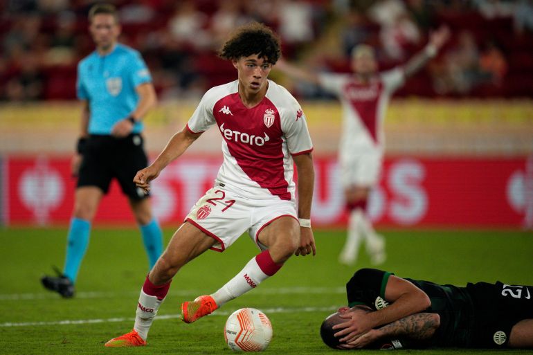 Monaco's Maghnes Akliouche, controls the ball as Ferencvaros' Endre Botka, lays on the pitch during the Europa League group H soccer match between Monaco and Ferencvaros at the Stade Louis II in Monaco, Thursday, Sept. 15, 2022. (AP Photo/Daniel Cole)